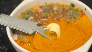 Suppenschüssel mit Wellenschliff-Löffel und Butter.