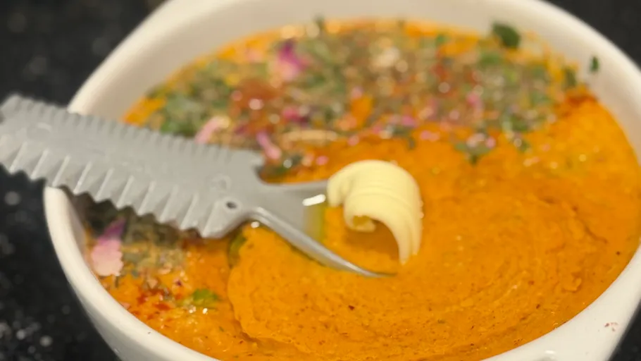 Soup bowl with serrated spoon and butter.