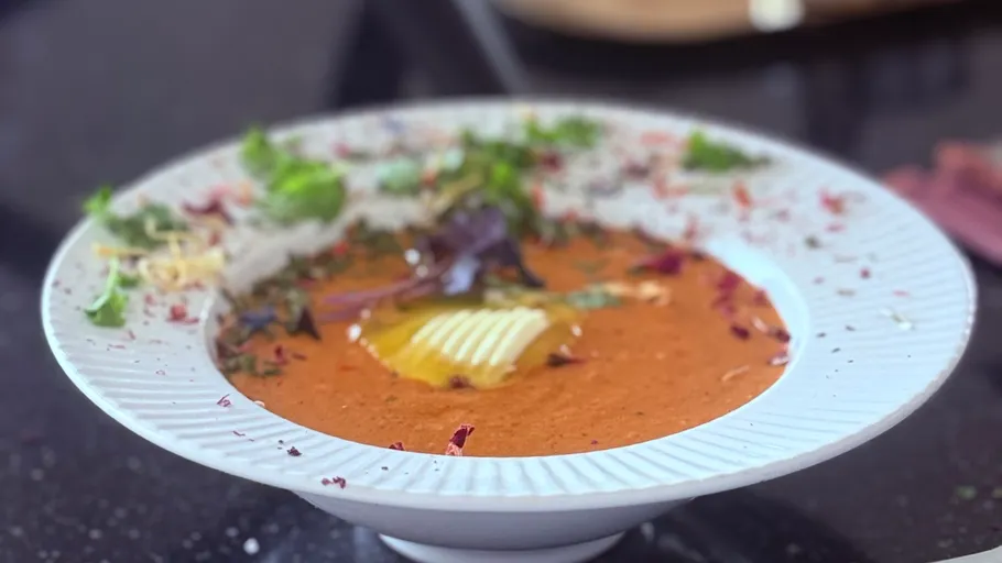 Soup with butter and herbs in bowl.