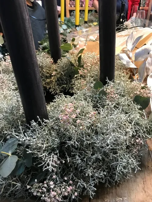 Decorative plants with yellow candles in background.