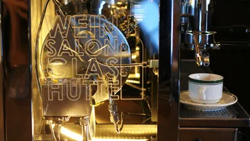 Espresso machine with coffee cup nearby.