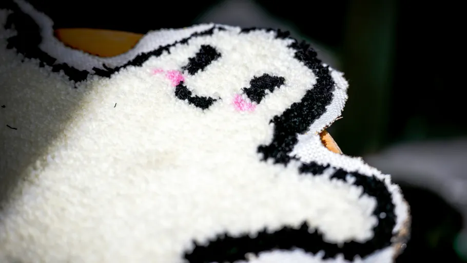 Weißer Geisterteppich mit fröhlichem Gesichtsmuster.