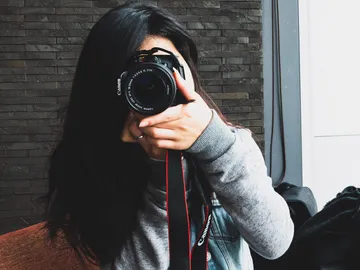 Kamera in der Hand, Person fotografiert sich selbst.