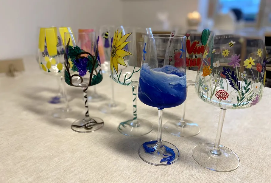 Colorful hand-painted wine glasses on table.