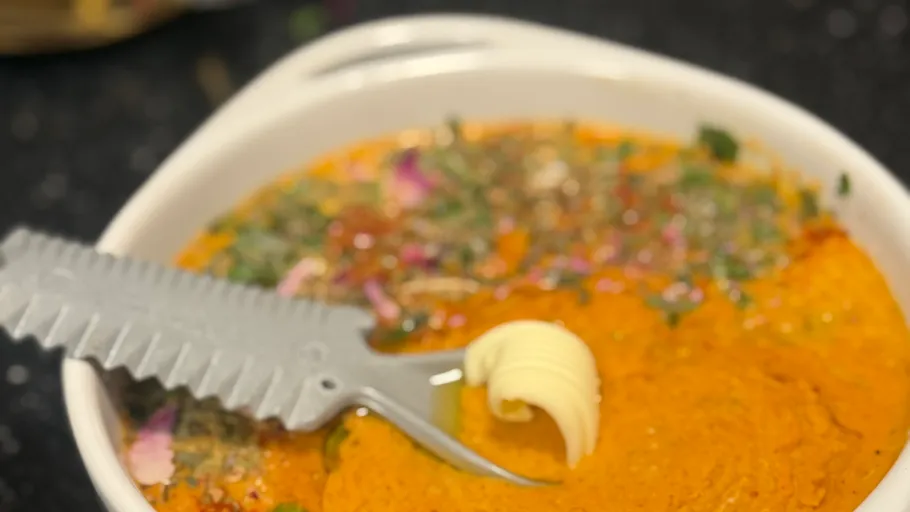 White bowl with vibrant orange curry.