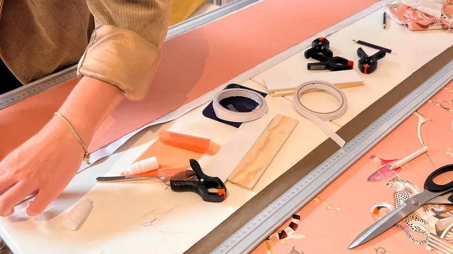 Person crafting with tools on a table.