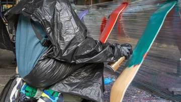 Person sprüht Skateboard-Decks im Freien an.