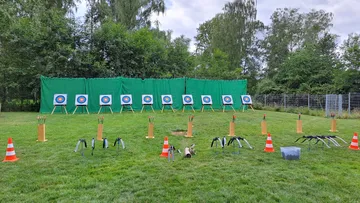 Archery targets and equipment on grassy field.