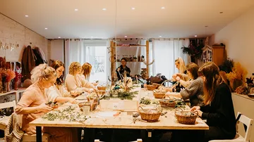 Women crafting at a long wooden table.
