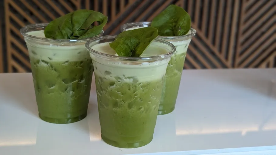 Three iced matcha drinks with leaves on top.