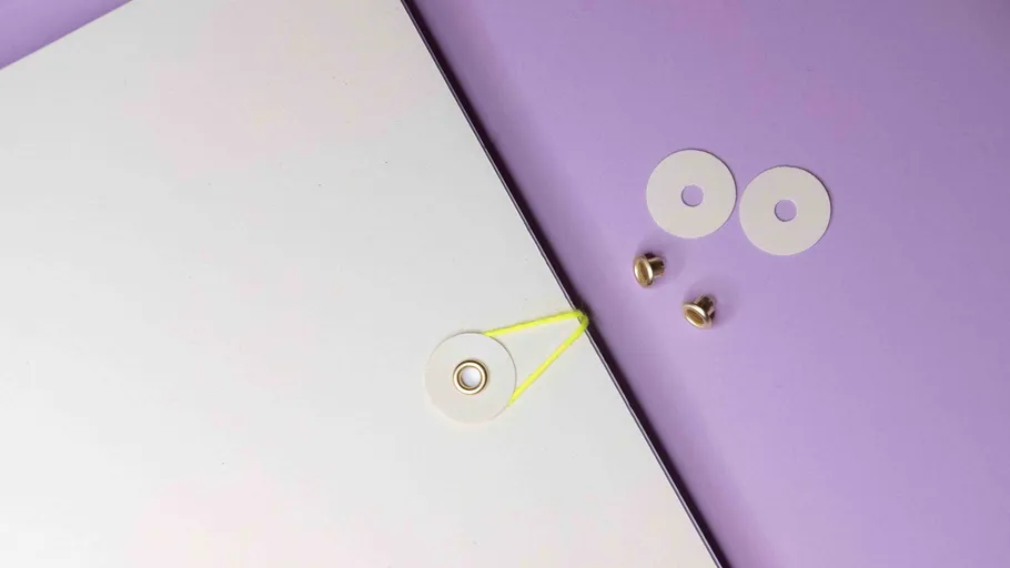 White board with washers on a purple surface.