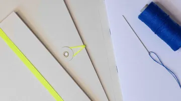 Notebooks with colorful thread and needle.