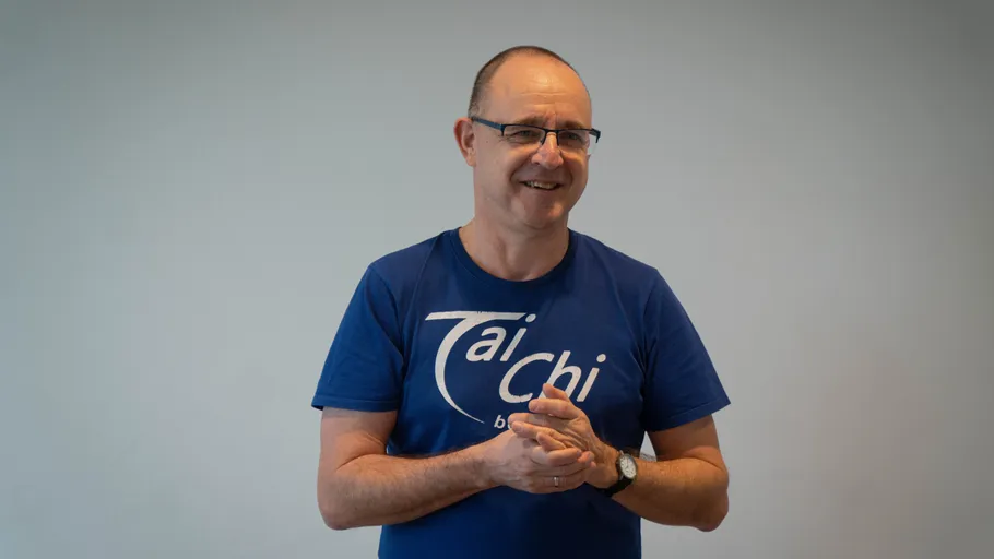 Mann im blauen Shirt lächelt drinnen.