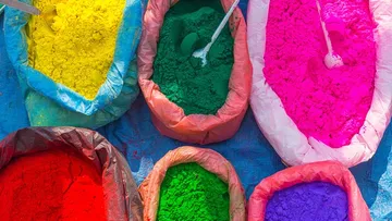 Colorful powders in bags on a blue surface.