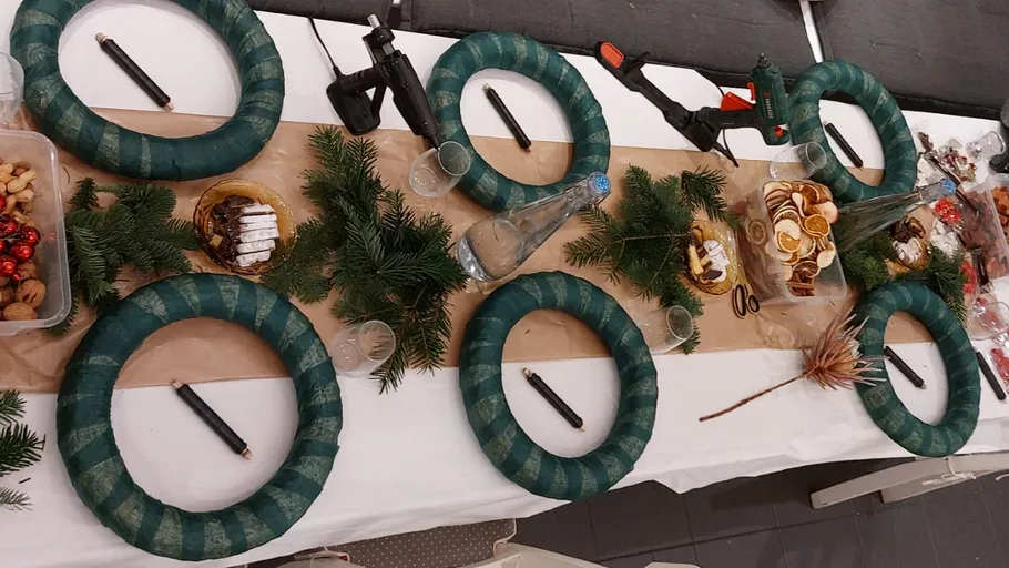 Basteltisch mit Kränzen und Materialien.