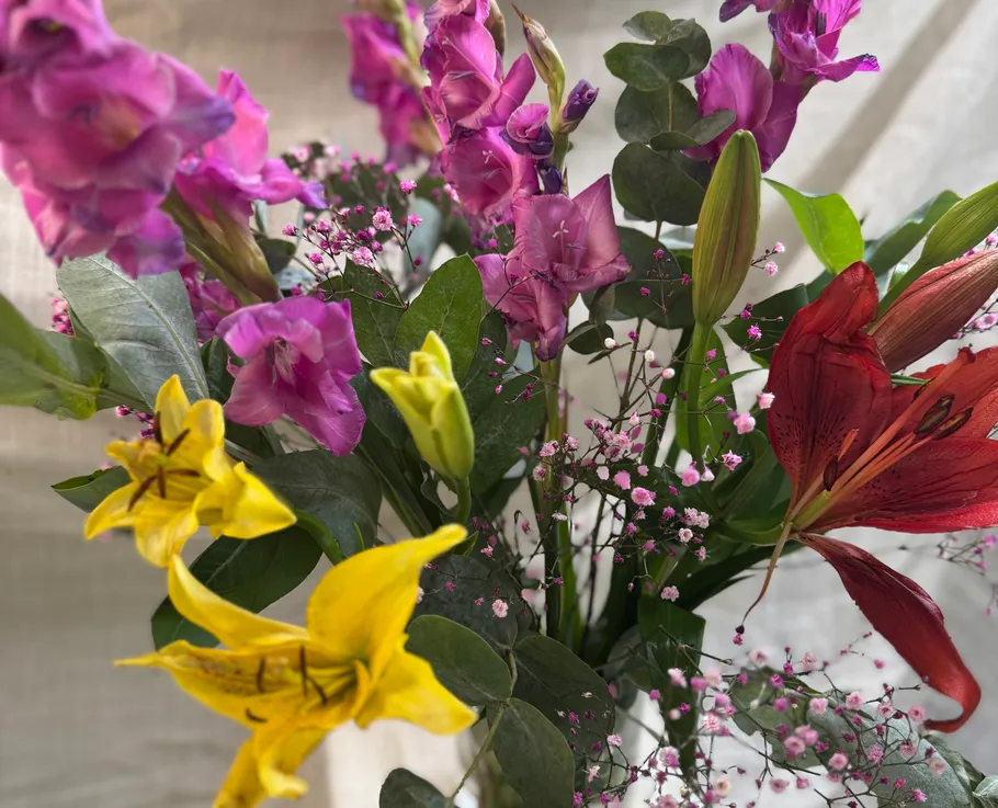 Bunter Blumenstrauß mit Lilien und Grün.