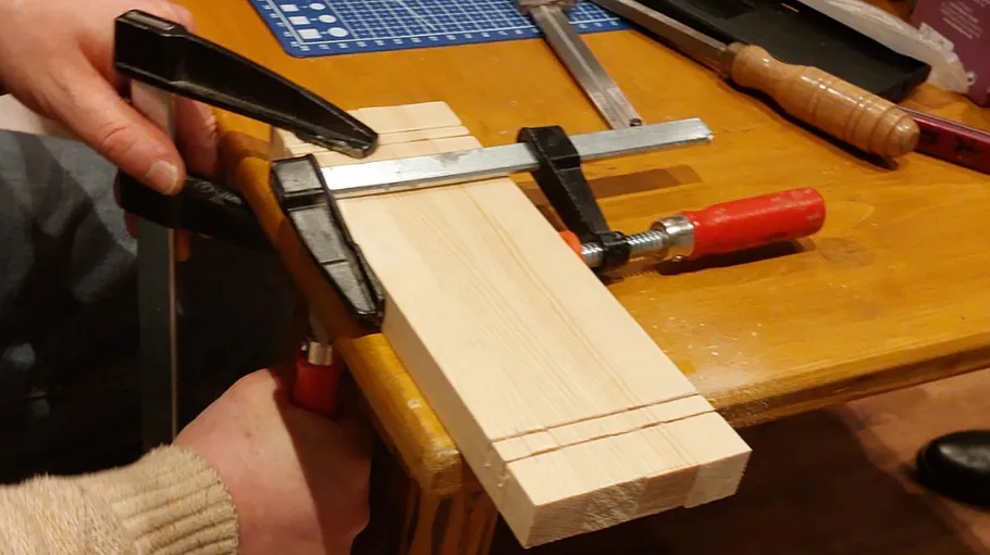 Wood clamped on table for cutting.