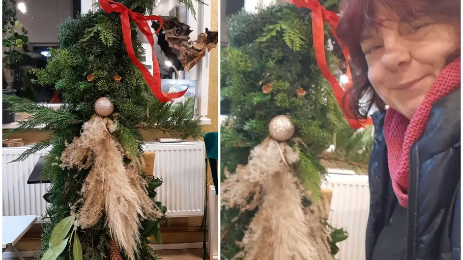 Woman smiling beside tree-like holiday decoration.