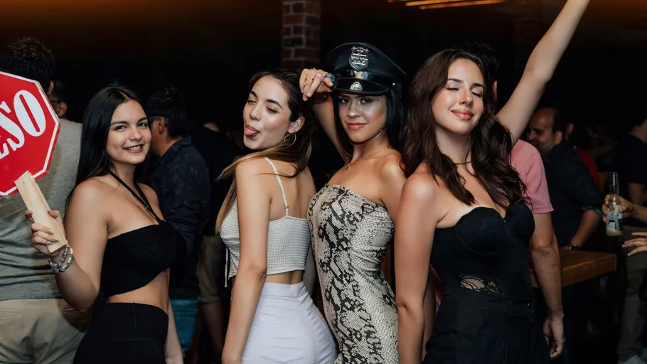 Vier Frauen posieren auf einer lebhaften Party.