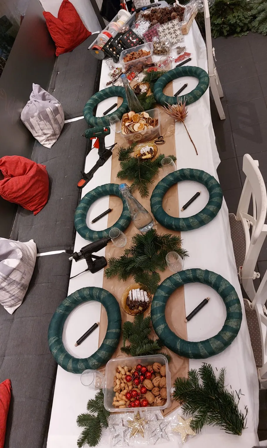 Table with wreath-making supplies and decorations.