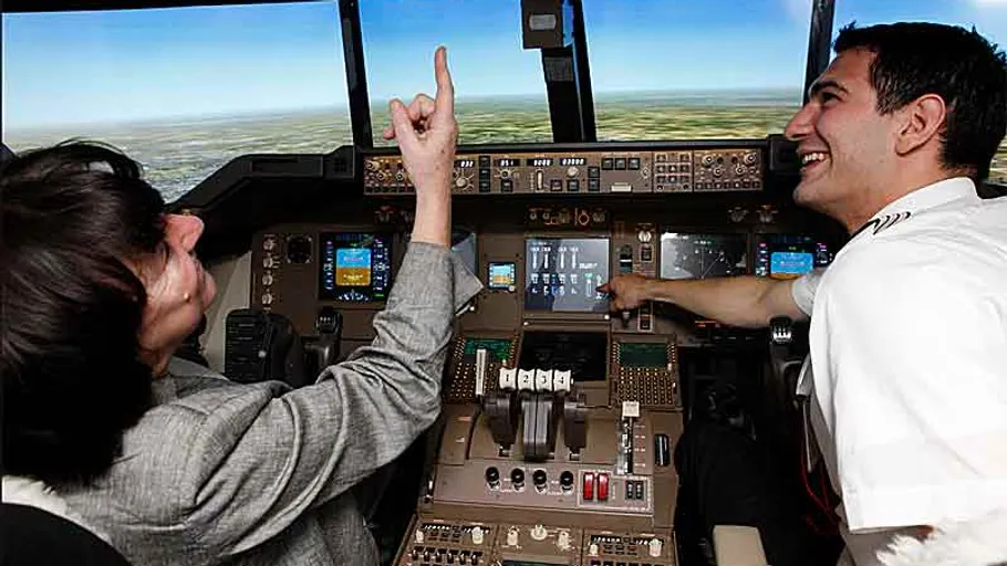 Zwei Personen im Flugzeugcockpit interagieren.