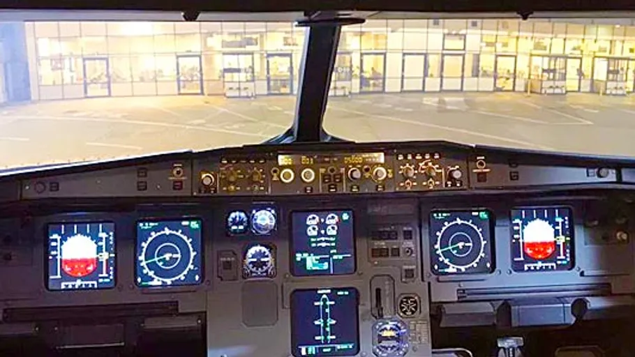 Flugzeugcockpit mit beleuchteten Instrumententafeln.