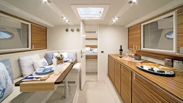 Modern yacht cabin with dining table setup.