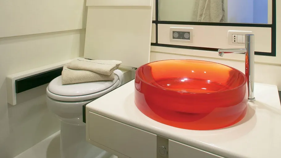 Rotes Waschbecken und Toilette im modernen Bad.