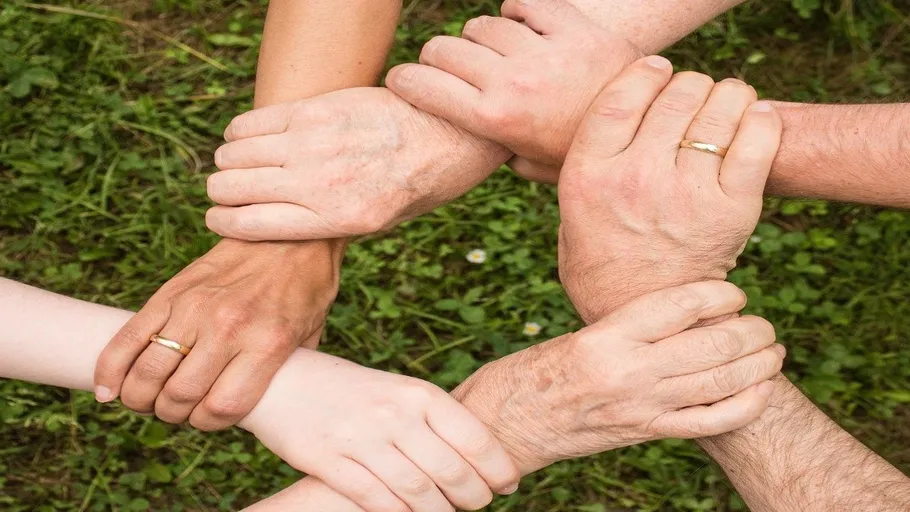 Hands forming a circle on grass.