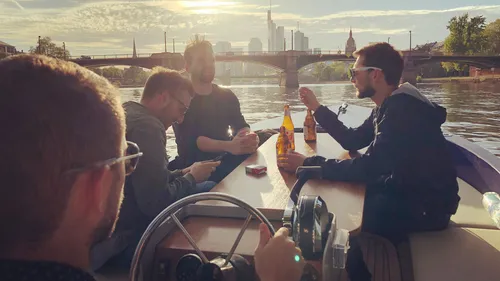 Four people relaxing on a boat, city backdrop.
