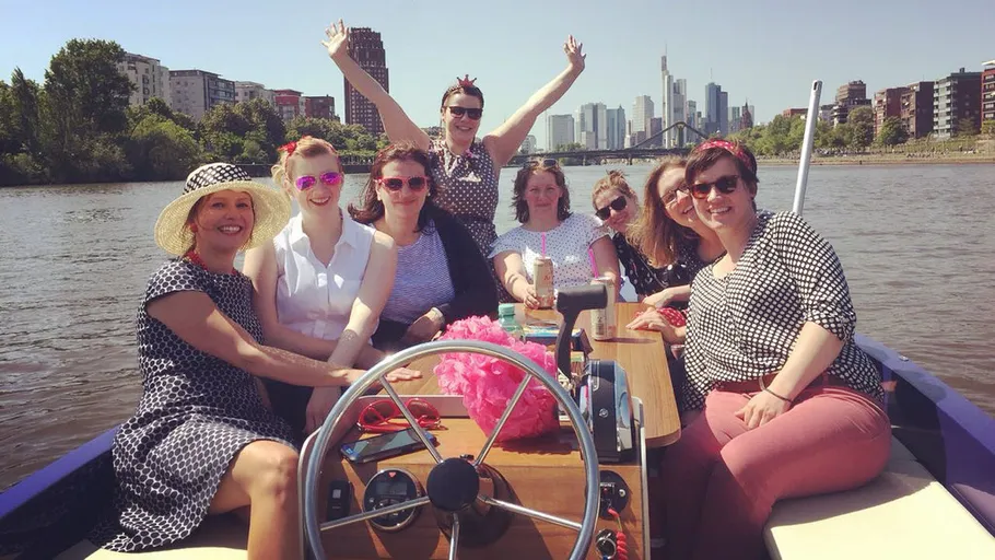 Gruppe fährt auf einem Boot in einer Flussstadt.