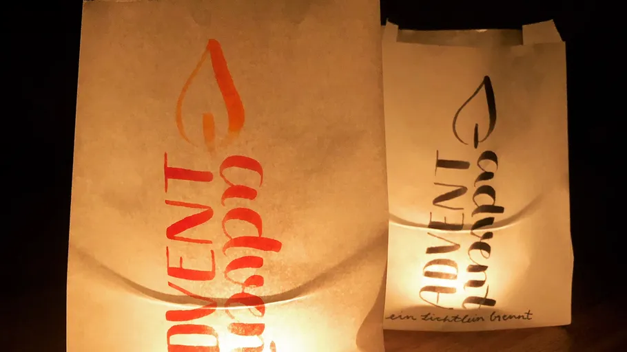 Zwei Laternen mit Advent-Aufschriften leuchten.