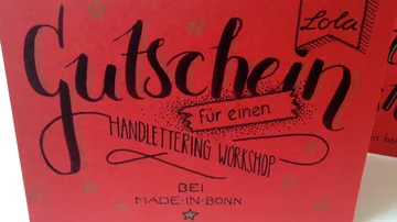 Rote Karte mit Handlettering-Workshop-Gutschein.