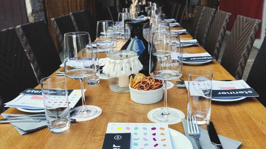 Table set with glasses and menus, outdoor setting.
