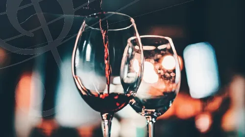 Rotwein wird in Glas eingeschenkt, Restaurantambiente.