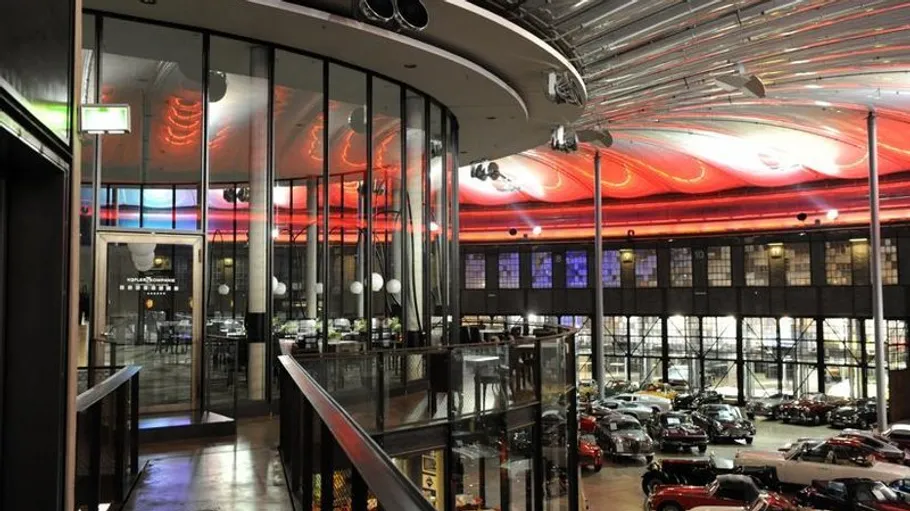 Indoor view of a car showroom with red lights.