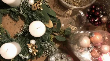 Weihnachtskranz mit Kerzen und Ornamenten.