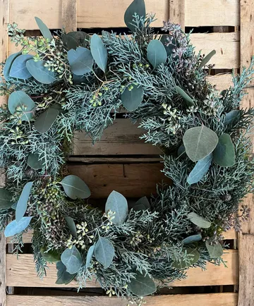 Green wreath on wooden crate background.