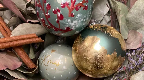 Decorated ornaments resting on dried leaves.