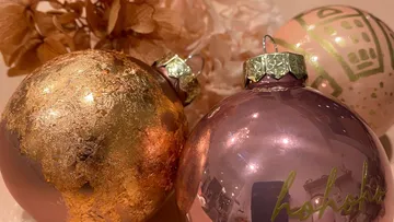 Drei dekorierte Weihnachtskugeln aufgestellt.