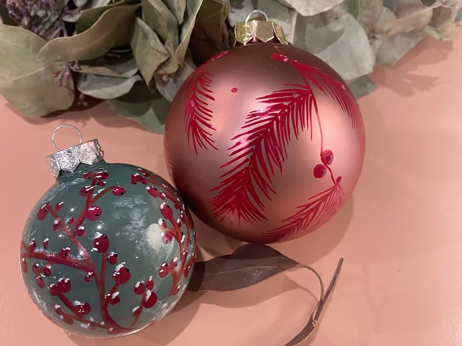 Two Christmas ornaments with leaf patterns.