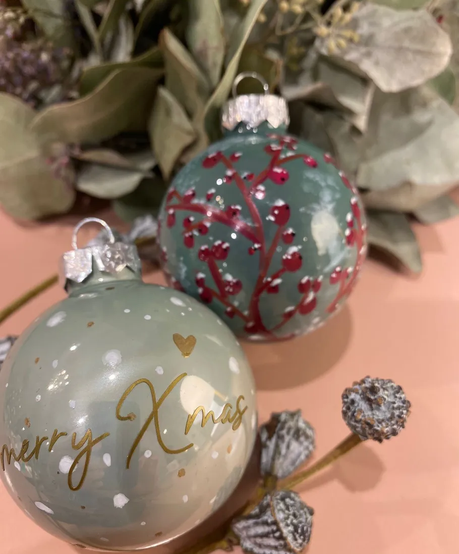 Christmas baubles with leaves and berries.