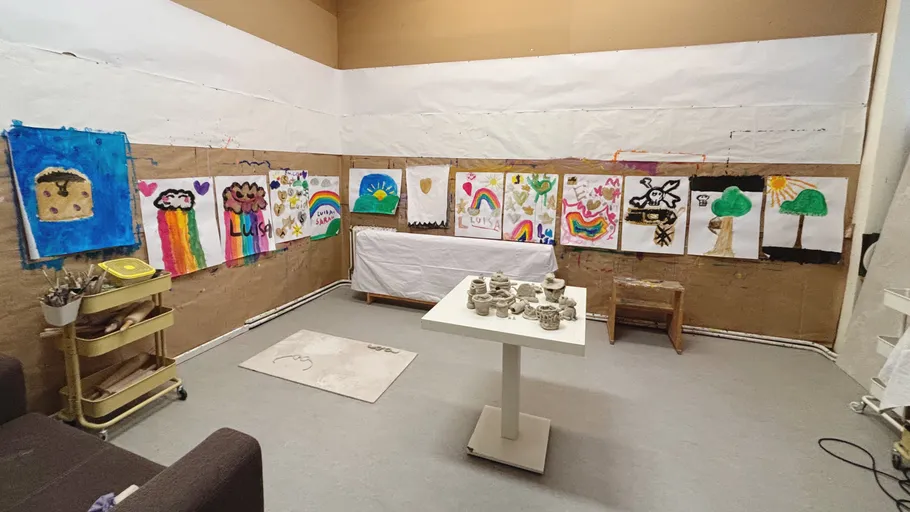 Colorful children's artwork displayed on room walls.