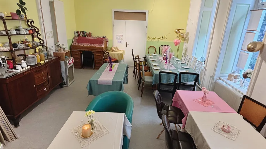 Gemütliches Café mit bunten Tischen und Stühlen.