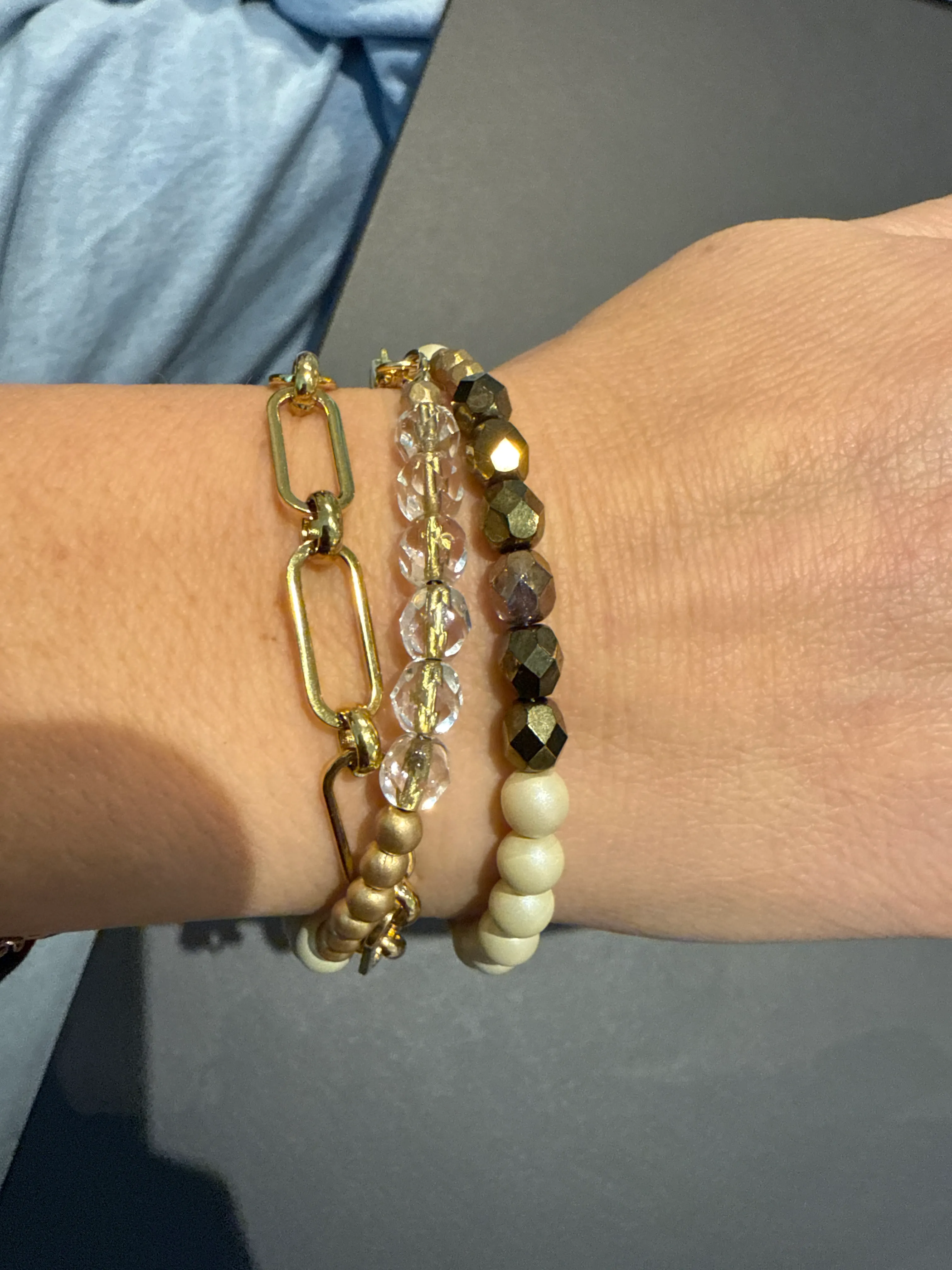 Handgelenk mit mehreren Armbändern getragen.