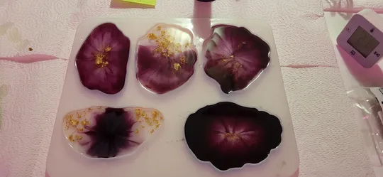 Purple resin coasters on white paper background.
