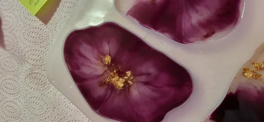 Purple resin art with gold accents on paper.