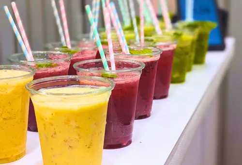 Colorful smoothies in cups lined up.