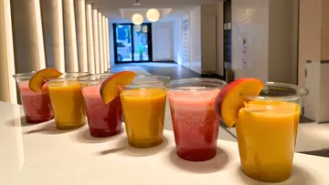 Bunte Getränke mit Fruchtgarnitur auf Tresen.