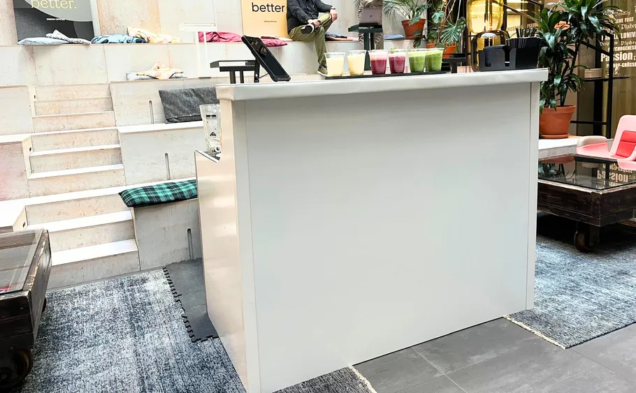 Weißer Tresen mit verschiedenen Smoothies, Innenbereich.